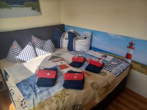 una cama con almohadas y una pintura de un faro en Bungalow by the Baltic Sea with Parking, en Hohenkirchen