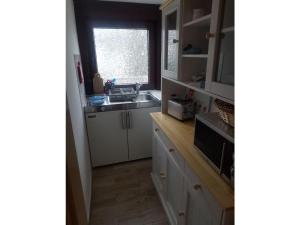 una cocina con fregadero y ventana en Bungalow by the Baltic Sea with Parking, en Hohenkirchen