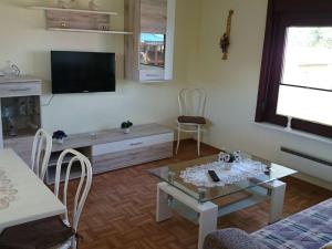 Una sala de estar con una mesa y un televisor. en Bungalow by the Baltic Sea with Parking, en Hohenkirchen