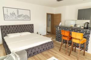 a bedroom with a bed and a table and chairs at Infinit Apartment in Prishtinë