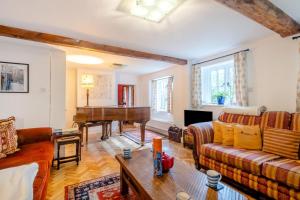 a living room with a couch and a piano at Dyes Cottage in Hindolveston
