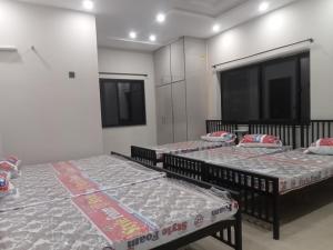 ラホールにあるFamily Guest house Rooms For Rentの部屋に3つのベッドがあるグループ