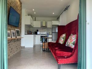 a living room with a red couch and a kitchen at Clear Skies in Kempton Park