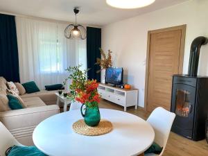 a living room with a table and a living room with a fireplace at Košutica Vila in Koraćica
