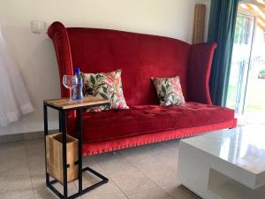 a red couch in a living room with a table at Clear Skies in Kempton Park