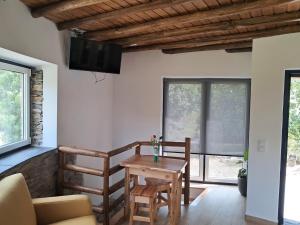 a living room with a table and chairs and a television at AL Rossadas Giesta in Arganil