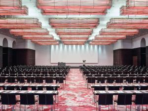 an empty lecture hall with chairs and a projection screen at Sofitel Munich Bayerpost in Munich +199 photos