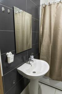 a bathroom with a sink and a mirror at Infinit Apartment in Prishtinë +12 photos