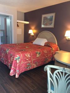 Habitación de hotel con cama con manta roja en Royal Court Motel, en Wildwood