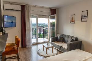 a living room with a couch and a balcony at Infinit Apartment in Prishtinë