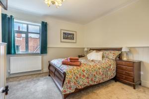 een slaapkamer met een bed, een dressoir en een raam bij The Anchorage - Snettisham in Snettisham +15 foto's