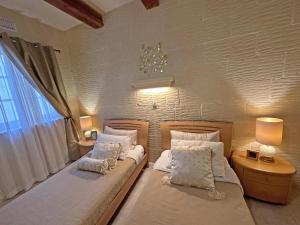 a bedroom with two beds and a window at Villa Ambrose Village in San Lawrenz +18 photos