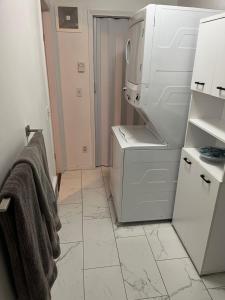 a kitchen with a white refrigerator and a tiled floor at Lake View Suite, Forest Retreat, Balfour BC in Balfour