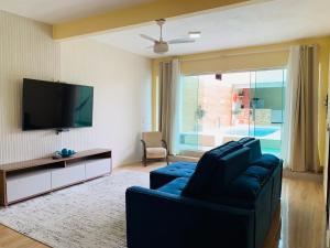 a living room with a couch and a flat screen tv at Jesaluguel-de-casa in Cabo Frio