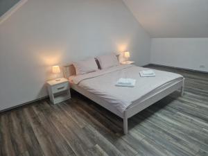 a bedroom with a bed with two lamps on it at Sunny Hill Apartments in Sînpetru