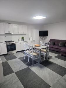a kitchen with a table and chairs and a couch at Sunny Hill Apartments in Sînpetru