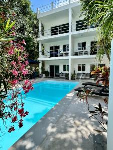 una imagen de una piscina frente a un edificio en Aqua Guesthouse, en Puerto Morelos