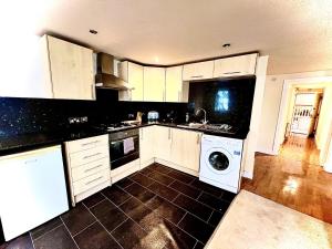 a kitchen with white cabinets and a washing machine at 2 bed Town Apartment in Shifnal