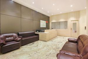 a lobby with two leather chairs and a desk at Hotel O Pearl City in Vidya Nagar