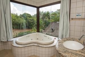 a bath tub in a bathroom with a window at Pousada Valle dos Pássaros in Penedo +142 photos