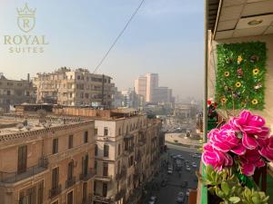 einen Blick auf die Stadt aus einem Fenster mit rosa Blumen in der Unterkunft Downtown Royal Suites in Kairo