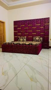 Cama en habitación con pared púrpura en Rest & stay, en Karachi
