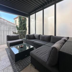 a living room with a couch and a table at Spacieux T3 en duplex rénové avec terrasse in Saint-Rémy-de-Provence