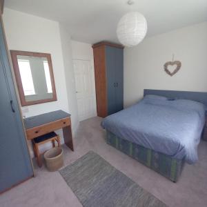 a bedroom with a bed and a mirror and a sink at 2 Cois Farraige in Kilkee +2 photos