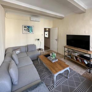 a living room with a couch and a flat screen tv at Spacieux T3 en duplex rénové avec terrasse in Saint-Rémy-de-Provence