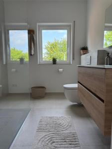 a bathroom with a toilet and a sink and two windows at Ferienwohnungen Archie oder Lilli,Nähe Europa Park, Strasbourg, Schwarzwald in Schutterwald +29 photos