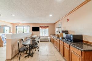 una cocina con una mesa y una encimera en Capital O Fairway Inn - Baytown La Porte TX, en La Porte