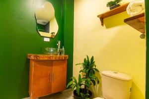 a green bathroom with a sink and a toilet at Waikiki Beach Boutique Hostel in Dibulla +35 photos