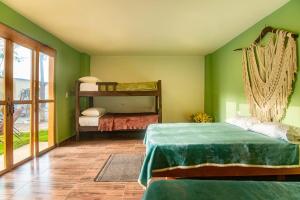 a bedroom with two beds in a room with green walls at Waikiki Beach Boutique Hostel in Dibulla