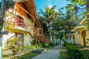a building with palm trees next to a street at Waikiki Beach Boutique Hostel in Dibulla