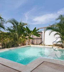a swimming pool with palm trees in the background at Casa Patio in Brisas de Zicatela +22 photos