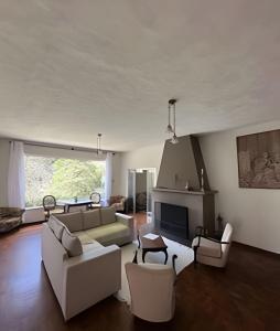 Una sala de estar con muebles blancos y chimenea. en Pousada Sítio São Luiz - Café da Manhã Piscina - Petrópolis, en Petrópolis