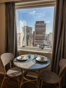 a table in a window with a view of a city at Ao lado da Paulista e metrô lazer completo com estac in Sao Paulo