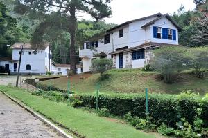 a white house on top of a hill at Pousada Sítio São Luiz - Café da Manhã Piscina - Petrópolis in Petrópolis
