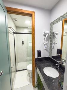 a bathroom with a shower and a sink and a toilet at FLAT CAMBUCI - Hospedagem e Moradia - Centro de Ipiaú-BA in Ipiaú