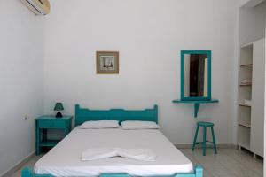 a bedroom with a bed and a mirror and a stool at Miltiadis Apartments in Ambelas
