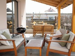 a patio with two chairs and a grill and a table at Apartmány Staroměstská romance in Staré Město