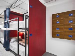 a room with two bunk beds and a red wall at Kinboshi Silom in Bangkok +78 photos