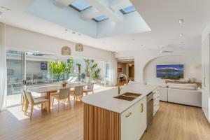 Una cocina y una sala de estar con mesa y sillas. en Luxury Dream Home Away From Home&heated pool, en Deception Bay