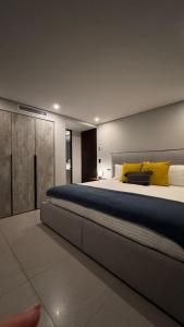a bedroom with a large bed with yellow pillows at Distrito Chapultepec in Guadalajara