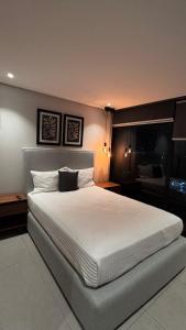 a bedroom with a large bed with white sheets at Distrito Chapultepec in Guadalajara
