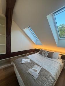 a bedroom with a bed with two towels on it at V&V Sky in Neuchâtel