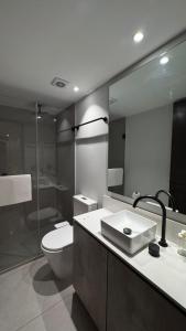 a bathroom with a toilet and a sink and a mirror at Distrito Chapultepec in Guadalajara