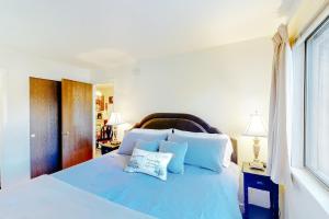 een slaapkamer met een blauw bed met 2 kussens bij Red Pine N1 in Park West Ski Area Heliport