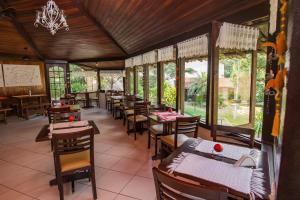 a dining room with tables and chairs and windows at Pousada Valle dos Pássaros in Penedo