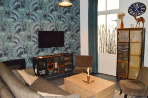 un salon avec un canapé et une télévision sur un mur dans l'établissement Nid du marché hypercentre La Rochelle, wifi, à La Rochelle